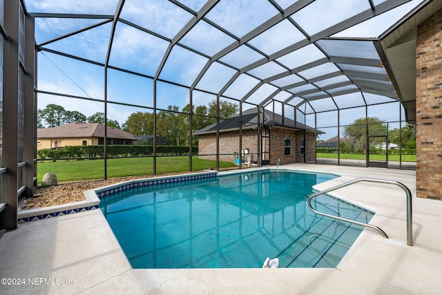 view of pool featuring a yard, a patio area, and glass enclosure