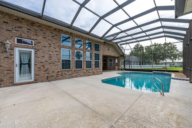 view of swimming pool featuring a patio area and a lanai