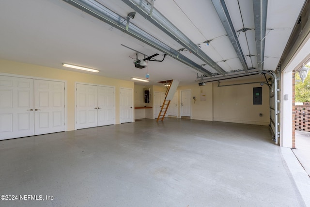 garage with a garage door opener and electric panel