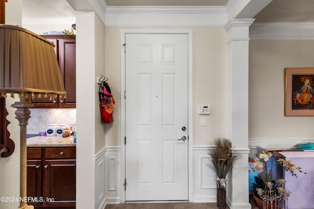 foyer featuring ornamental molding and ornate columns