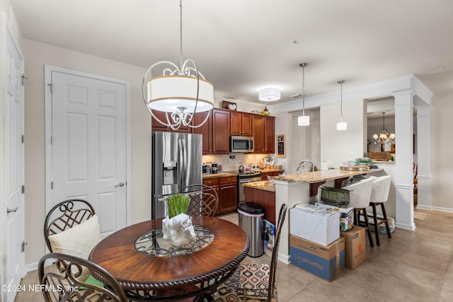 9831 Del Webb Pkwy Unit 2308, Jacksonville, FL 32256 - dining room featuring a chandelier, light tile patterned floors, and decorative columns