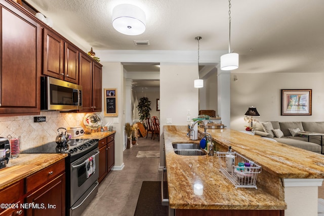9831 Del Webb Pkwy Unit 2308, Jacksonville, FL 32256 - kitchen featuring stainless steel appliances, open floor plan, tasteful backsplash, light stone counters, and pendant lighting