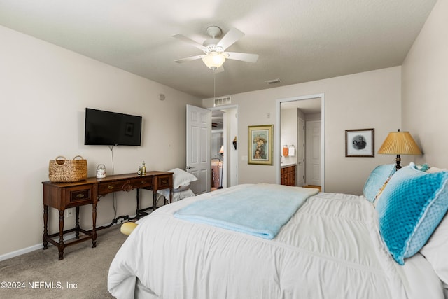 carpeted bedroom featuring ensuite bathroom, ceiling fan, and a textured ceiling