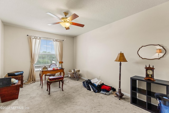 misc room with a textured ceiling, light carpet, and ceiling fan