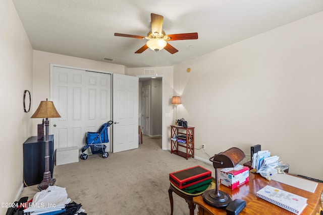 carpeted home office featuring ceiling fan