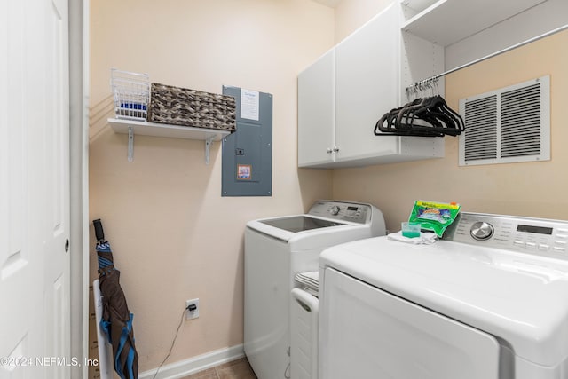 washroom with electric panel, cabinets, washing machine and clothes dryer, and tile patterned floors