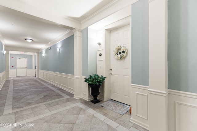 entryway with ornate columns and crown molding