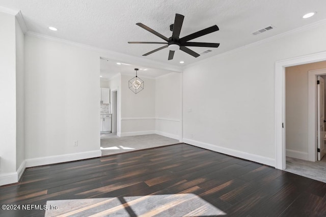 unfurnished room with ceiling fan, dark hardwood / wood-style floors, a textured ceiling, and ornamental molding