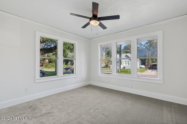 carpeted spare room with a textured ceiling and ceiling fan