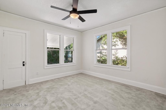 carpeted spare room with a textured ceiling and ceiling fan