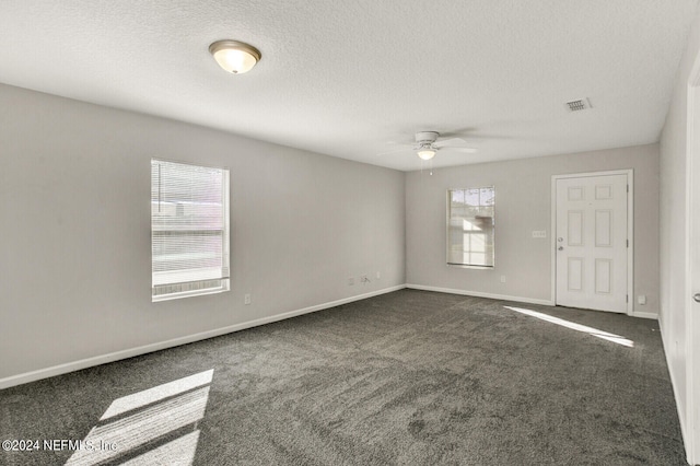 carpeted spare room featuring ceiling fan and a textured ceiling