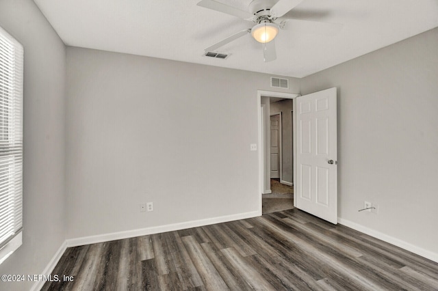 spare room with ceiling fan, a healthy amount of sunlight, and dark hardwood / wood-style flooring