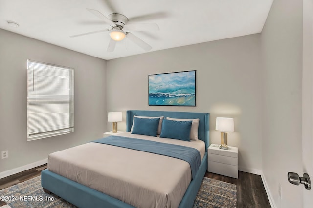 bedroom with dark hardwood / wood-style flooring and ceiling fan