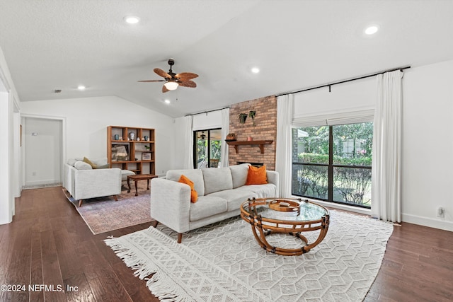 living room with ceiling fan, dark wood-type flooring, a fireplace, and vaulted ceiling