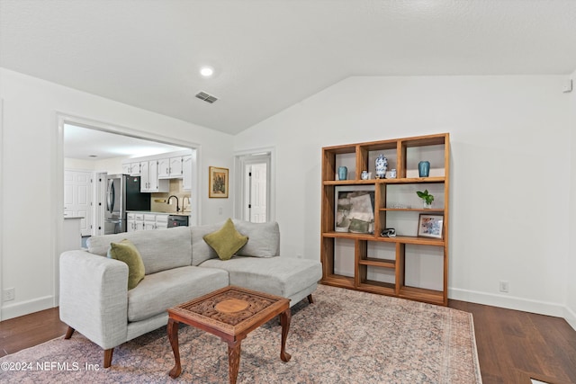 living room featuring sink, vaulted ceiling, and wood-type flooring