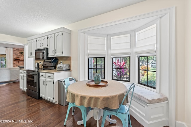 kitchen with electric stove, a textured ceiling, white cabinetry, dark wood-type flooring, and decorative backsplash