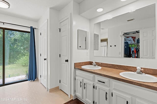 bathroom with vanity, a textured ceiling, and tile patterned floors