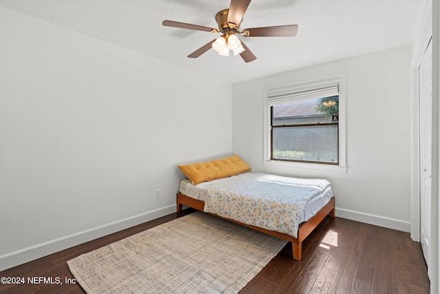 bedroom with dark hardwood / wood-style flooring and ceiling fan