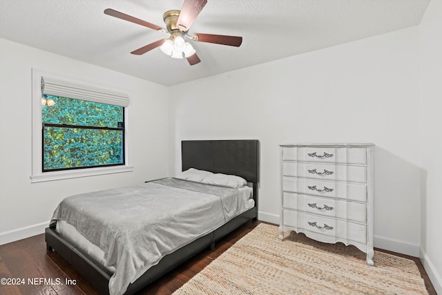 bedroom featuring a textured ceiling, dark hardwood / wood-style floors, and ceiling fan