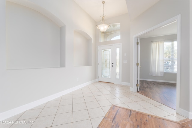 entryway with light hardwood / wood-style floors and a notable chandelier