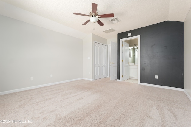 carpeted empty room with ceiling fan, a textured ceiling, and vaulted ceiling