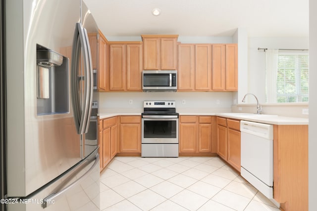 kitchen featuring light tile patterned flooring, stainless steel appliances, sink, and light brown cabinetry