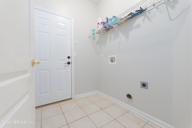 washroom featuring hookup for an electric dryer, hookup for a washing machine, and light tile patterned floors