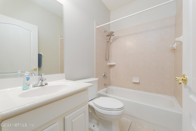 full bathroom featuring vanity, tiled shower / bath combo, toilet, and tile patterned flooring