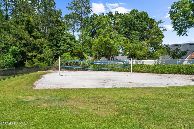 view of property's community featuring a lawn and volleyball court