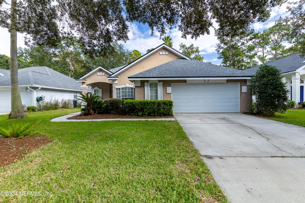 single story home featuring a garage and a front lawn