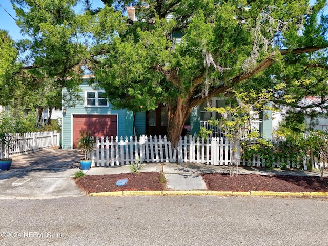 view of property hidden behind natural elements with a garage