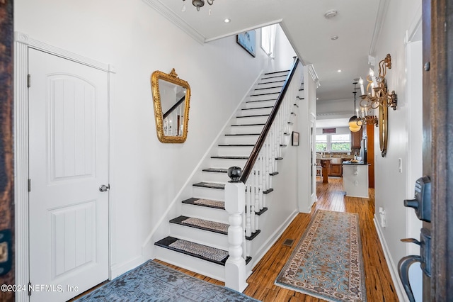 stairway featuring crown molding and wood-type flooring