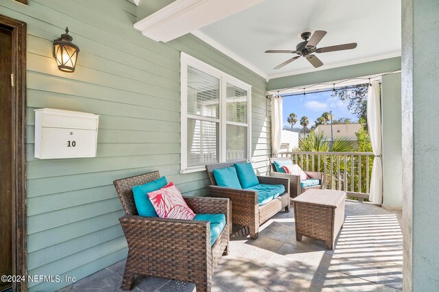 sunroom with ceiling fan and beam ceiling