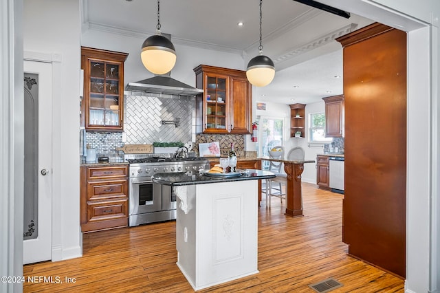 kitchen featuring light hardwood / wood-style floors, stainless steel appliances, a breakfast bar area, and hanging light fixtures