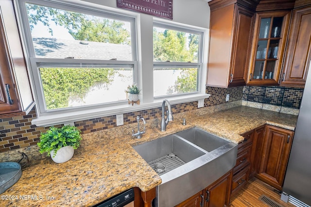 kitchen with light hardwood / wood-style flooring, tasteful backsplash, sink, and light stone counters