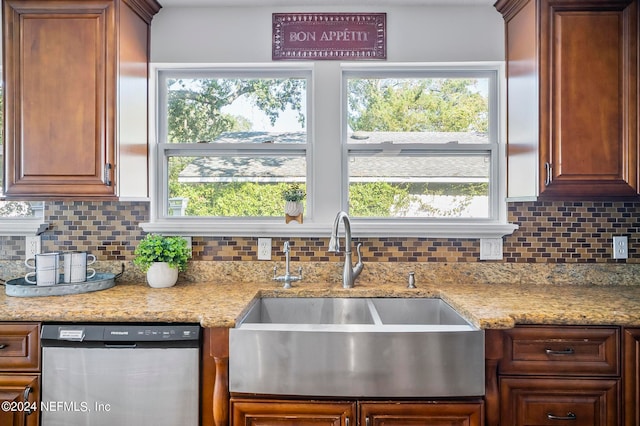 kitchen with tasteful backsplash, stainless steel dishwasher, sink, and plenty of natural light