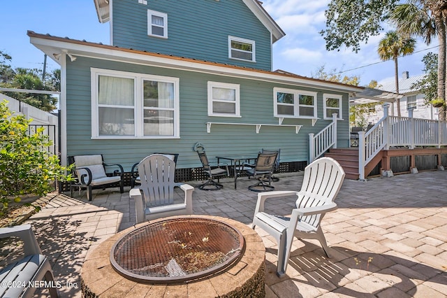 rear view of property with a patio and an outdoor fire pit