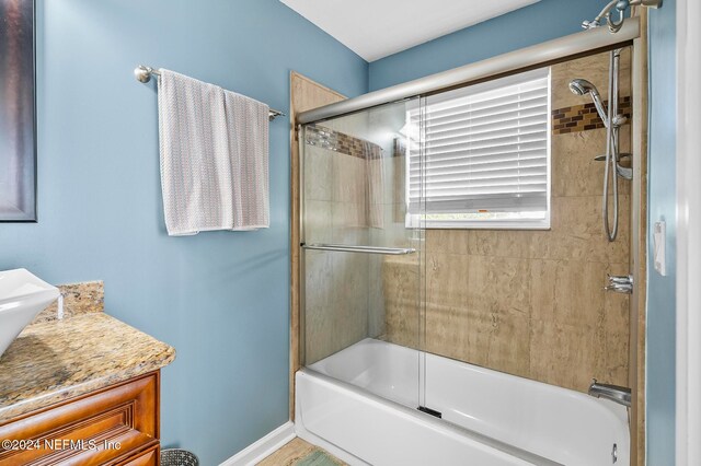 bathroom with vanity and enclosed tub / shower combo