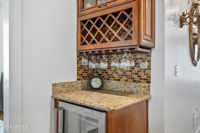 bar with light stone countertops, tasteful backsplash, and beverage cooler