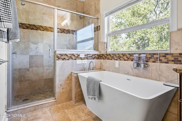 bathroom featuring tile walls and separate shower and tub