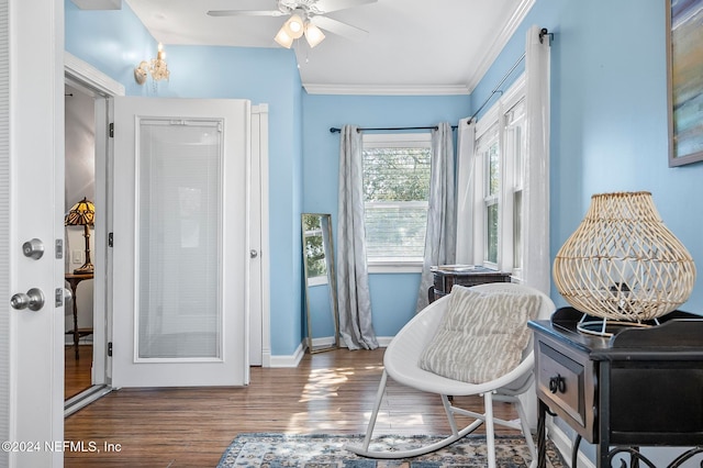 living area featuring crown molding, wood-type flooring, and ceiling fan