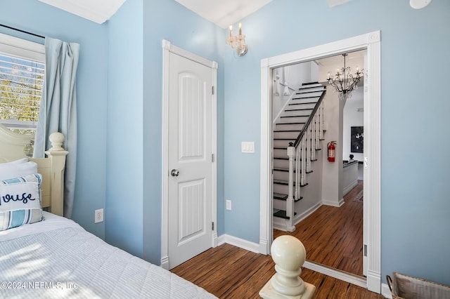 bedroom featuring a notable chandelier, dark hardwood / wood-style floors, and a closet