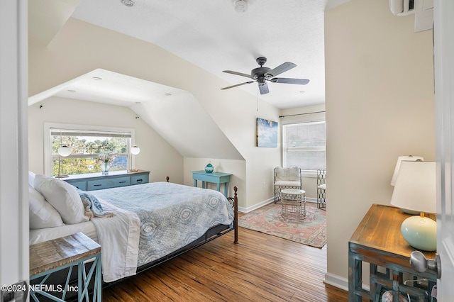 bedroom with ceiling fan, vaulted ceiling, and dark hardwood / wood-style floors