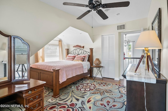 bedroom featuring a closet, light hardwood / wood-style flooring, multiple windows, and ceiling fan with notable chandelier