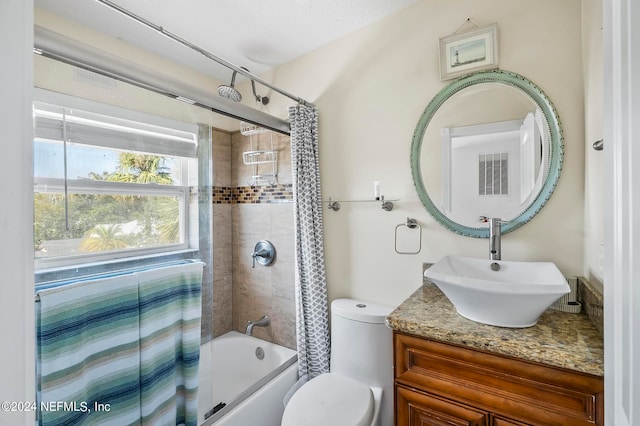 full bathroom with vanity, shower / tub combo with curtain, and toilet