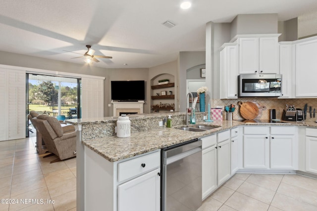 kitchen featuring sink, ceiling fan, stainless steel appliances, white cabinets, and light stone counters