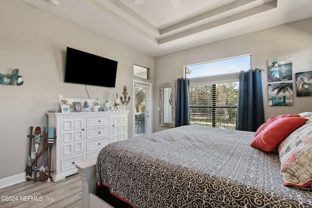 bedroom featuring ceiling fan, light hardwood / wood-style flooring, and access to exterior