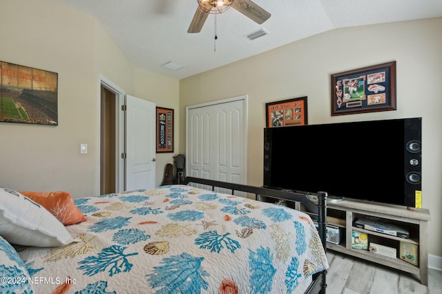 bedroom featuring light hardwood / wood-style floors, a closet, lofted ceiling, and ceiling fan