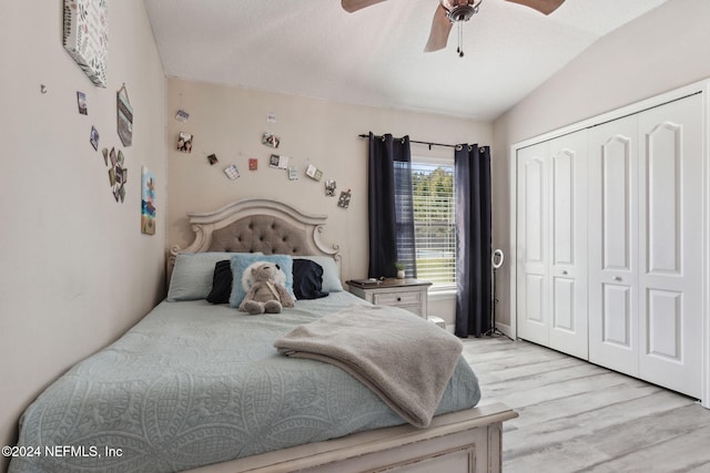 bedroom with light hardwood / wood-style floors, a closet, ceiling fan, and vaulted ceiling