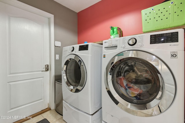 clothes washing area with light tile patterned flooring and washing machine and clothes dryer